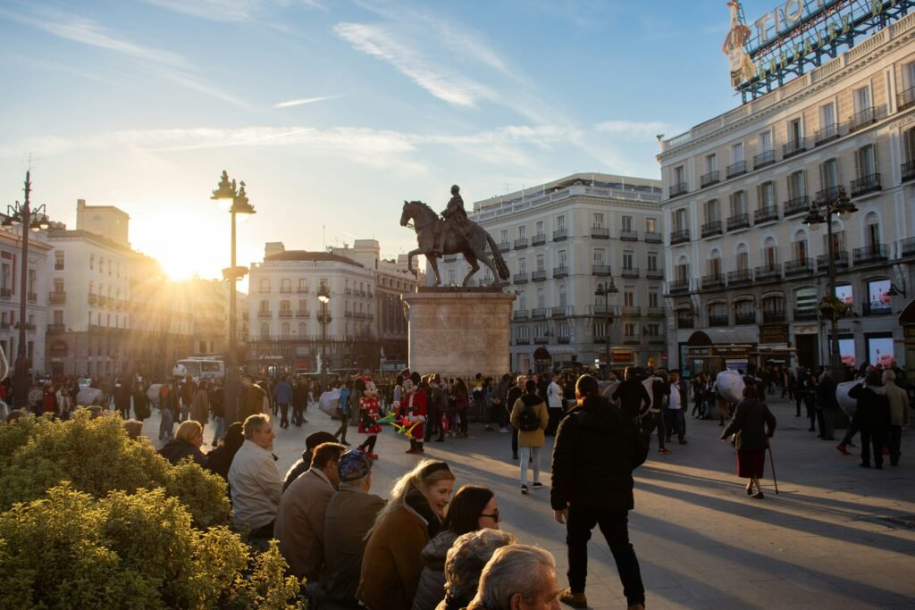 Crowds walking along Gran Vía in Madrid, Spain, on a sunny winter day with the iconic Schweppes building in the background. Madrid Winter Travel Guide 2025: Best Things to Do, See & Eat.